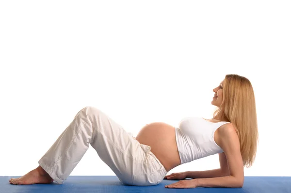 Těhotná žena vleže a cvičení jógy — Stock fotografie