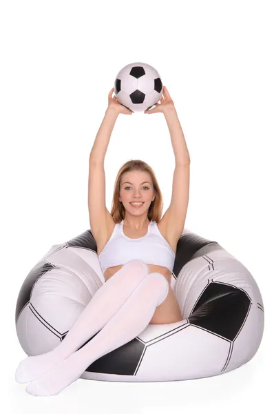 Женщина с футбольным мячом на надувном стуле — стоковое фото