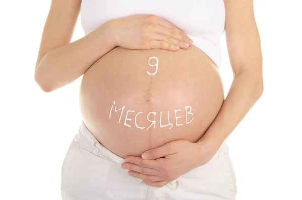 Kobieta w ciąży brzuch słowami dziewięć miesięcy — Zdjęcie stockowe