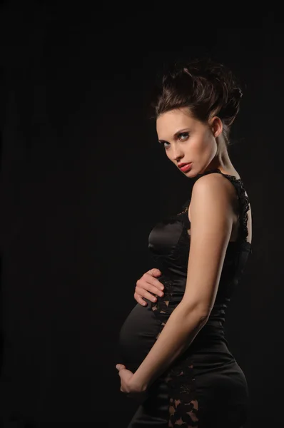 Schöne schwangere Frau im schwarzen Kleid — Stockfoto