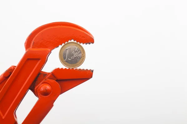 Llave naranja presionando una moneda de euro — Foto de Stock