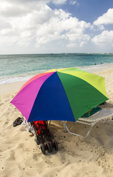 Песчаный пляж с цветным пляжным зонтиком — стоковое фото