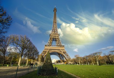 Curves of the Eiffel Tower under blue sky at shiny Winter mornin clipart