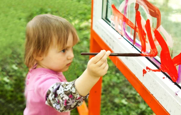 可爱的小女孩在玻璃上绘图 — 图库照片