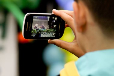 TERNOPIL, UKRAINE - MARCH 13: Boy is recording the show on openi clipart