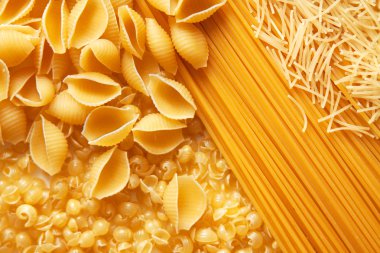 Close up shoot of different types of raw pasta. clipart