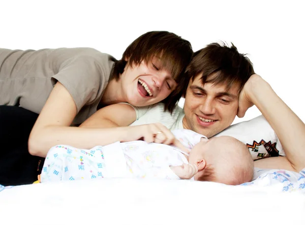 Jovem família divertida feliz com bebê deitado na cama em casa — Fotografia de Stock