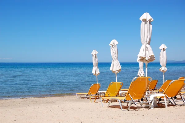 Sonnenliegen am Strand und türkisfarbenes Wasser im modernen Luxushotel — Stockfoto