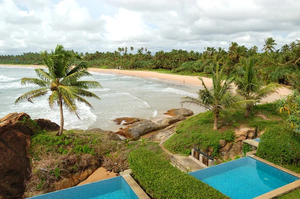 Бассейны с видом на пляж на роскошных виллах и бирюзовая вода — стоковое фото