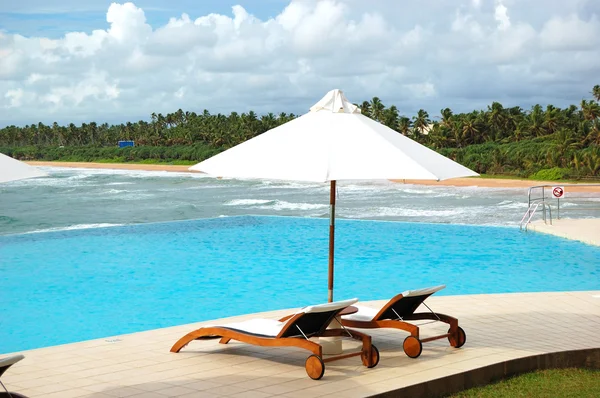 Лежаки у бассейна с видом на море, Бентота, Шри-Ланка — стоковое фото