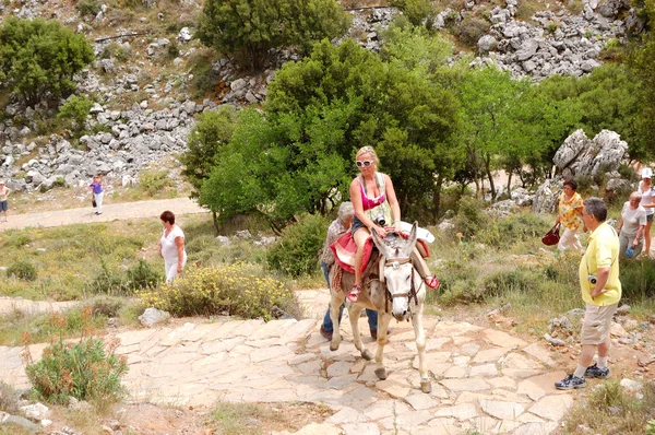 CRETE ISLAND, GREECE - MAY 13: The female tourist on a donkey an — Stock Photo, Image