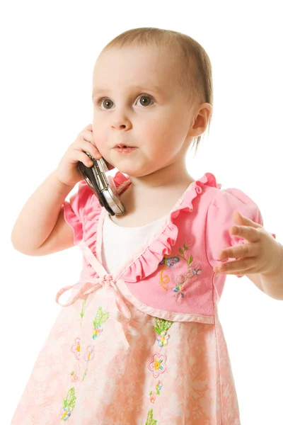 Holčička mluví po telefonu v růžových šatech — Stock fotografie