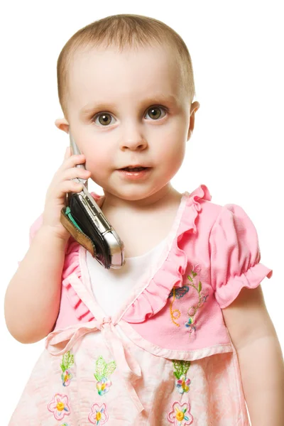 Lilla flickan talar i telefon i en rosa klänning — Stockfoto