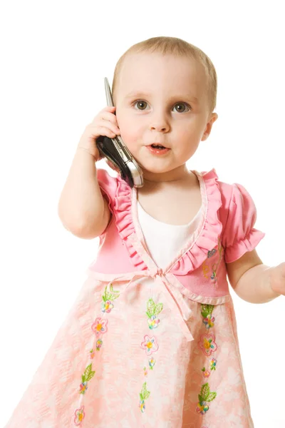 Lilla flickan talar i telefon i en rosa klänning — Stockfoto