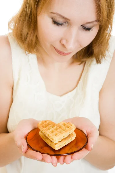 Femme tenant une assiette de biscuits en forme de coeur . — Photo
