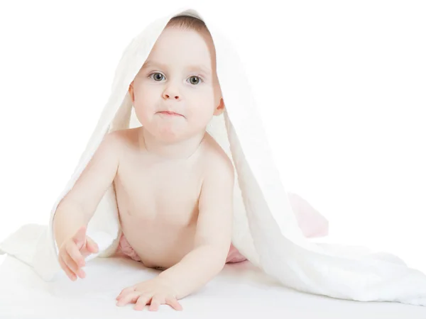 Bébé heureux sous une serviette sur fond blanc . — Photo