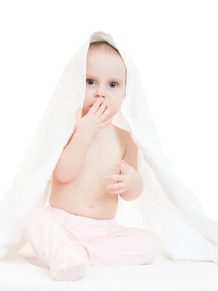 Bebê feliz sob uma toalha em um fundo branco . — Fotografia de Stock
