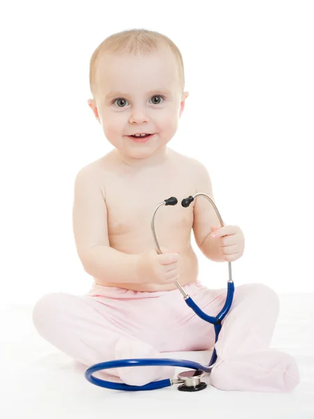 Happy baby med stetoskop på vit bakgrund. Royaltyfria Stockfoton