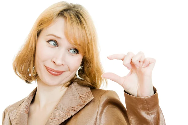 Uma mulher olha para um pequeno objeto em sua mão sobre um fundo branco . — Fotografia de Stock