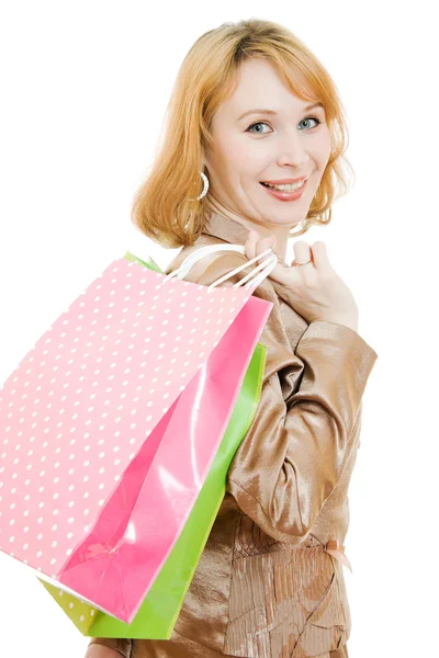 Een mooie vrouw in een gouden pak met winkelen op een witte achtergrond. — Stockfoto