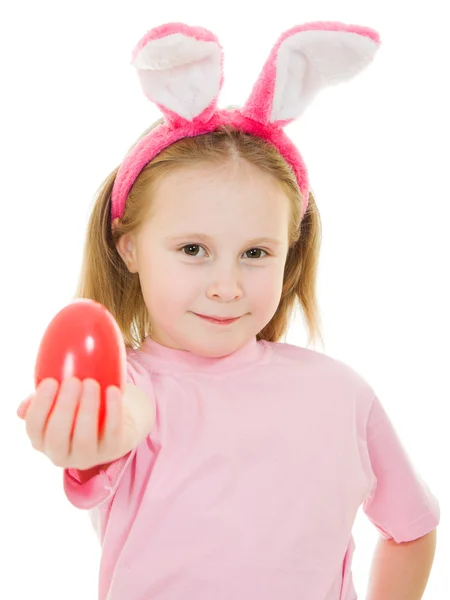 Holčička s růžové uši zajíčka s vejcem na bílém pozadí. — Stock fotografie