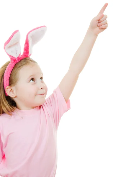 The little girl with pink ears bunny points to the top on white background. — Stock Photo, Image