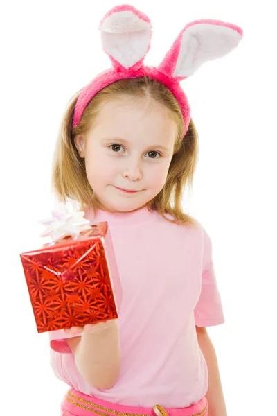 La niña con orejas rosadas conejito con un regalo sobre un fondo blanco . — Foto de Stock