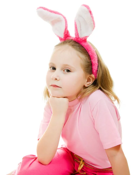 Holčička s růžové uši zajíčka na bílém pozadí. — Stock fotografie