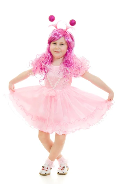 Una chica con el pelo rosa en un vestido rosa bailando sobre un fondo blanco . — Foto de Stock
