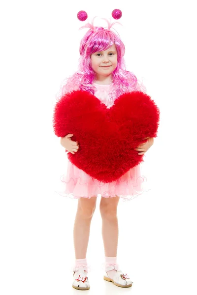A girl with pink hair and a pink dress holding a pillow in the shape of hea — Stock Photo, Image