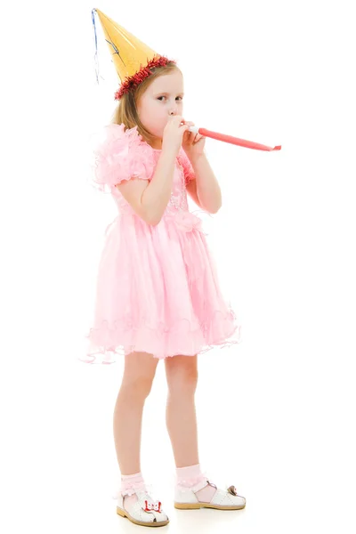 Dziewczyna w różowej sukience i kapelusz dmuchanie w rurze na białym tle. — Zdjęcie stockowe
