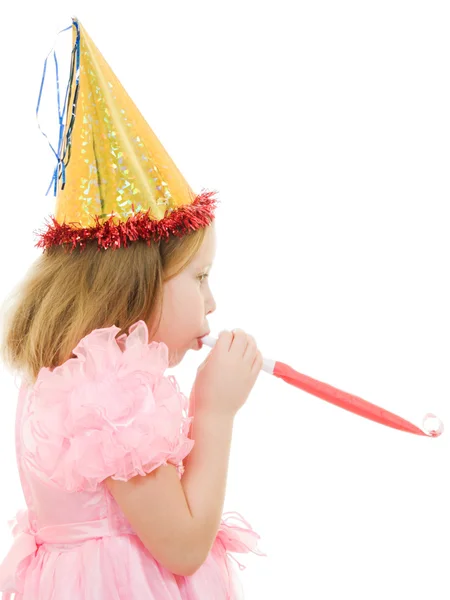 A girl in a pink dress and hat blowing in the pipe on a white background. — Stock Photo, Image
