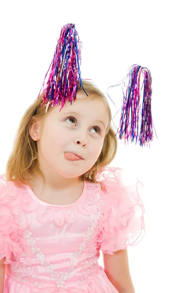 Vtipné děvče v růžových šatech s anténami na hlavě ukazuje jazyk na prostřené — Stock fotografie