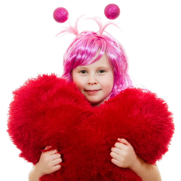 A girl with pink hair and a pink dress cuddle pillow in the form of the hea — Stock Photo, Image