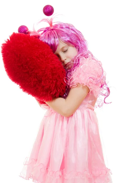 Una ragazza con i capelli rosa e un abito rosa coccolare cuscino in forma di hea — Foto Stock