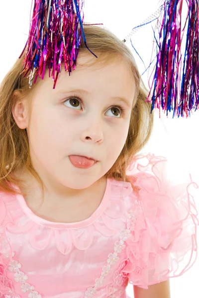 Αστείο κορίτσι σε ένα ροζ φόρεμα με κεραίες στο κεφάλι του παρουσιάζει γλώσσα σε ένα μόριο — Φωτογραφία Αρχείου
