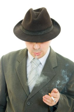 bir işadamı şapkalı beyaz bir arka plan üzerinde sigara içiyor..