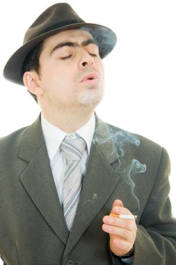 bir işadamı şapkalı beyaz bir arka plan üzerinde sigara içiyor..