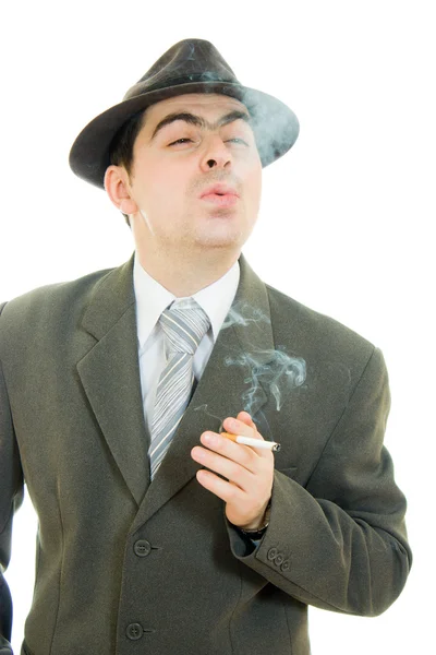 En affärsman i en hatt röker på vit bakgrund. — Stockfoto