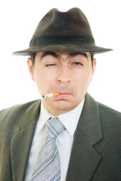 Um homem de negócios de chapéu fuma em um fundo branco . — Fotografia de Stock