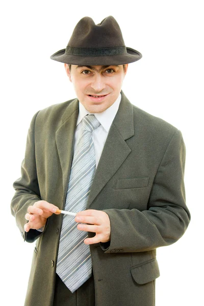 Een zakenman in een hoed rookt op een witte achtergrond. — Stockfoto