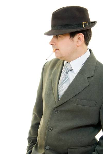 A businessman in a hat smokes on a white background. — Stock Photo, Image