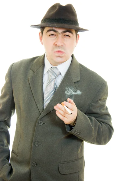 Un hombre de negocios con sombrero fuma sobre un fondo blanco . — Foto de Stock