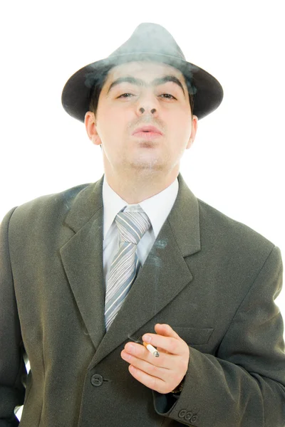 Бізнесмен у капелюсі курить на білому тлі . — стокове фото