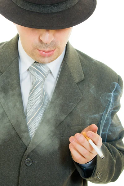 Bir işadamı şapkalı beyaz bir arka plan üzerinde sigara içiyor.. — Stok fotoğraf