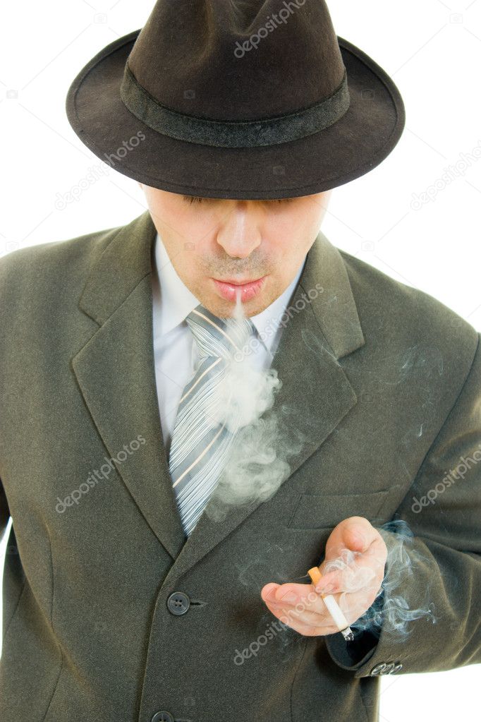 A businessman in a hat smokes on a white background.