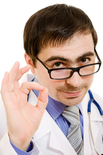 Beyaz bir arka plan üzerinde iyi bir doktor stetoskop ve gözlük bir jest ile gösterir — Stok fotoğraf