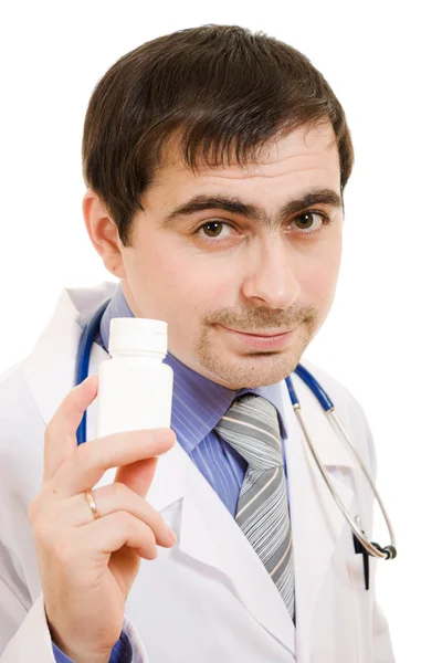 Il medico che tiene un contenitore di vitamine su uno sfondo bianco . — Foto Stock
