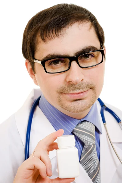 El médico que sostiene un recipiente de vitaminas sobre un fondo blanco . — Foto de Stock