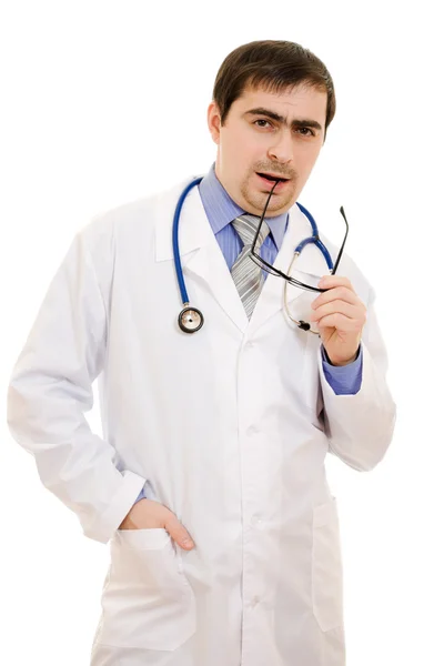 Um médico com um estetoscópio e óculos pensando em um fundo branco — Fotografia de Stock